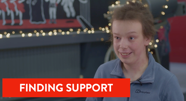 Student smiling by some fairy lights